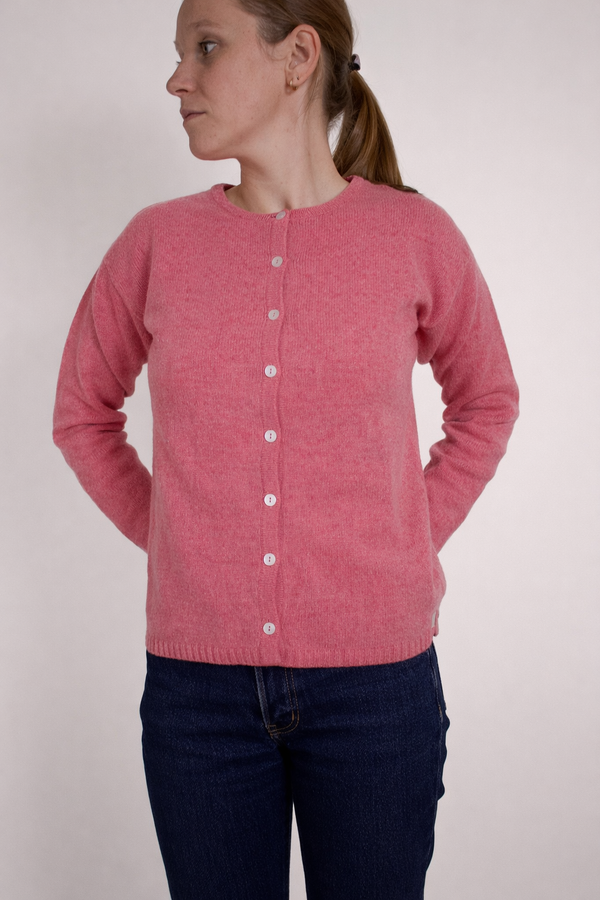 half british lambswool crew neck cardigan in pink, worn buttoned to the neck showing the soft knit texture