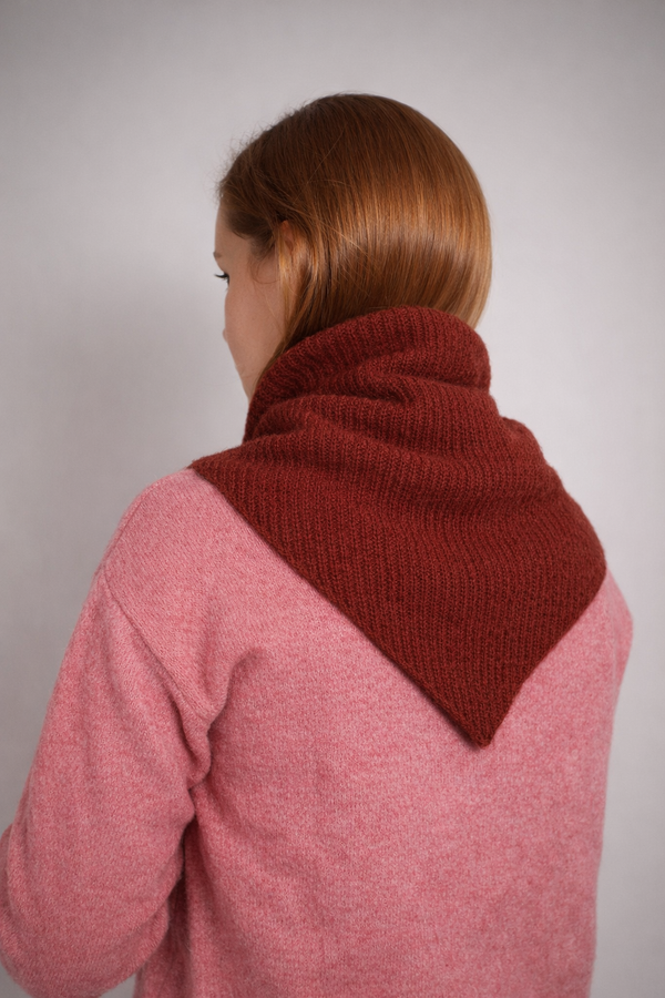 half british lambswool ribbed triangle scarf in rust, draped over the shoulders showing the ribbed knit texture