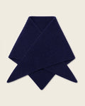 A folded ribbed knit scarf in deep navy blue, displayed on a solid light beige background.