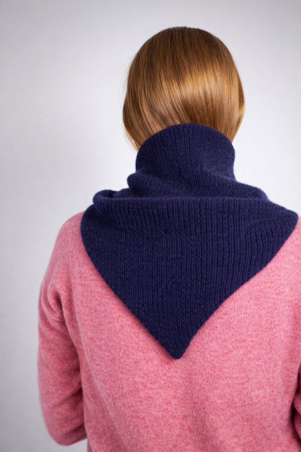 half british lambswool ribbed triangle scarf in navy, draped over the shoulders showing the ribbed knit texture