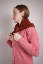 half british lambswool ribbed triangle scarf in rust, worn wrapped around the neck and tied at the front