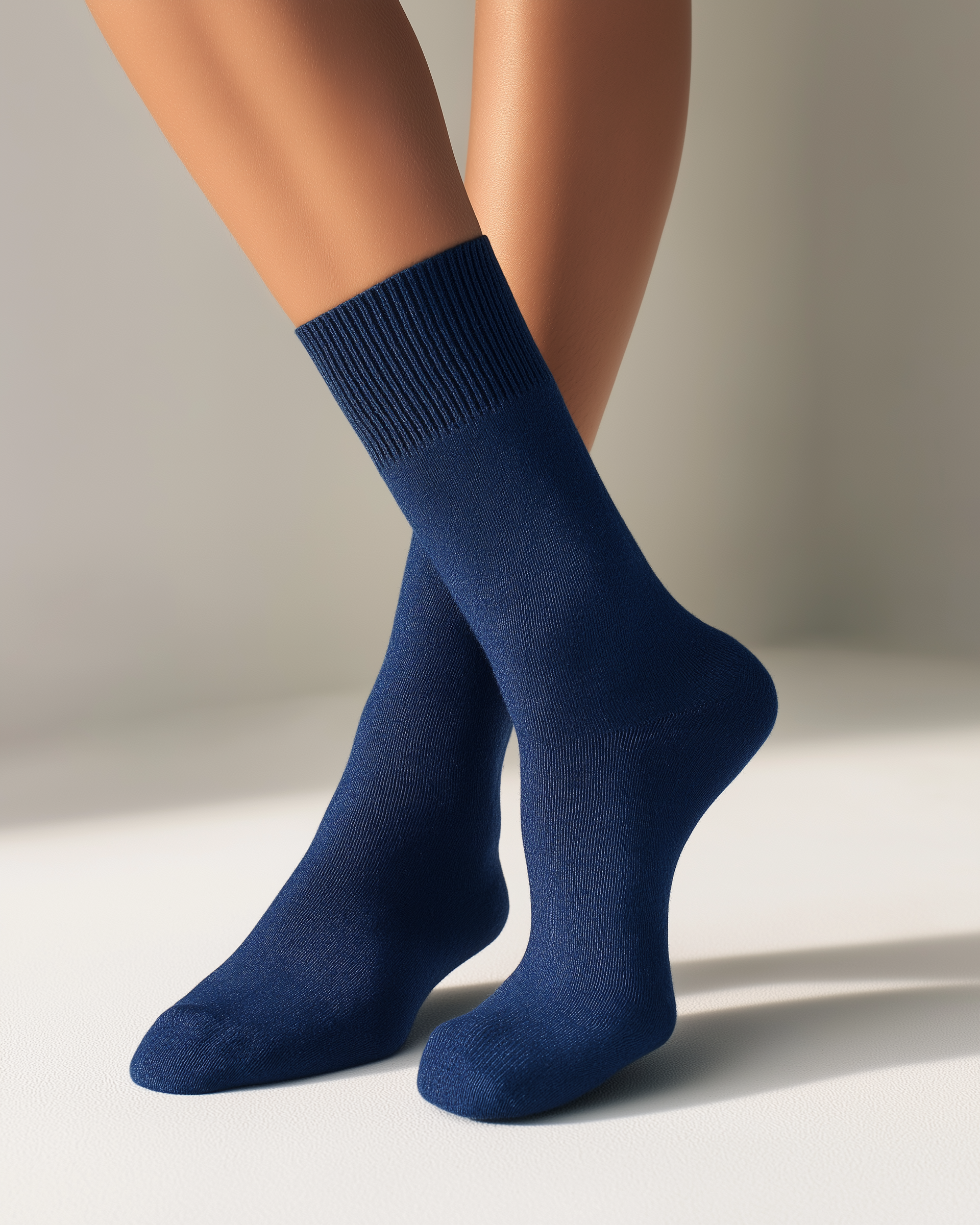 half british alpaca everyday socks in navy, worn in a soft-lit editorial setting with crossed legs on a neutral background, highlighting the fine alpaca texture and elegant minimal design