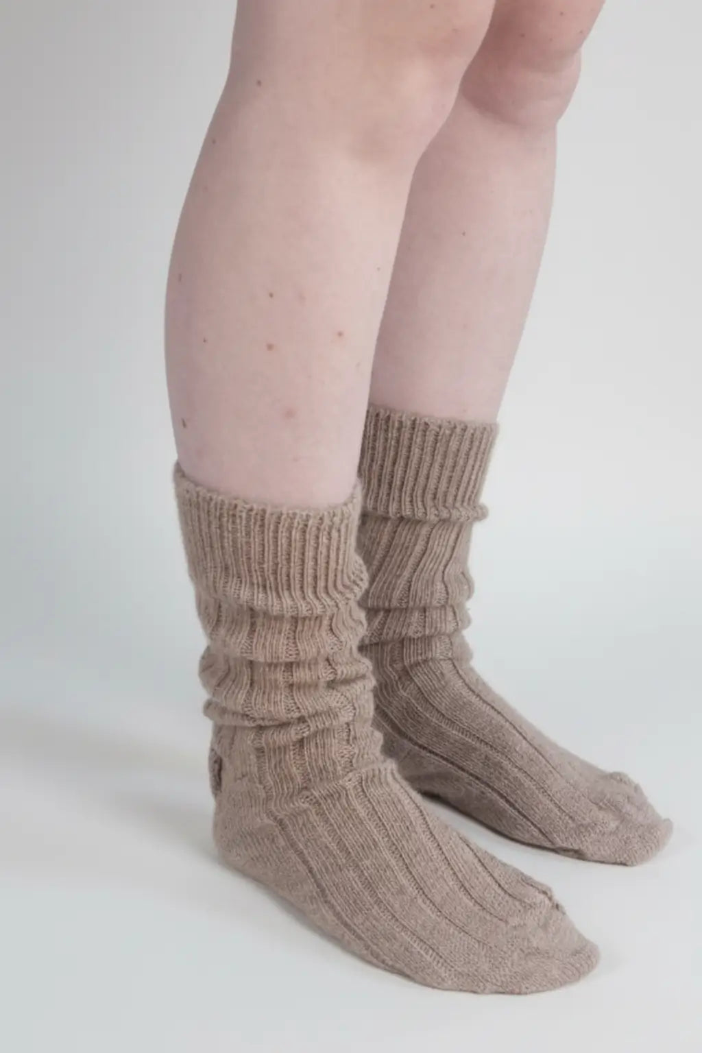 half british alpaca lounge socks in fawn, worn slightly slouched to show the ribbed knit texture and natural alpaca fibre softness against a white background.