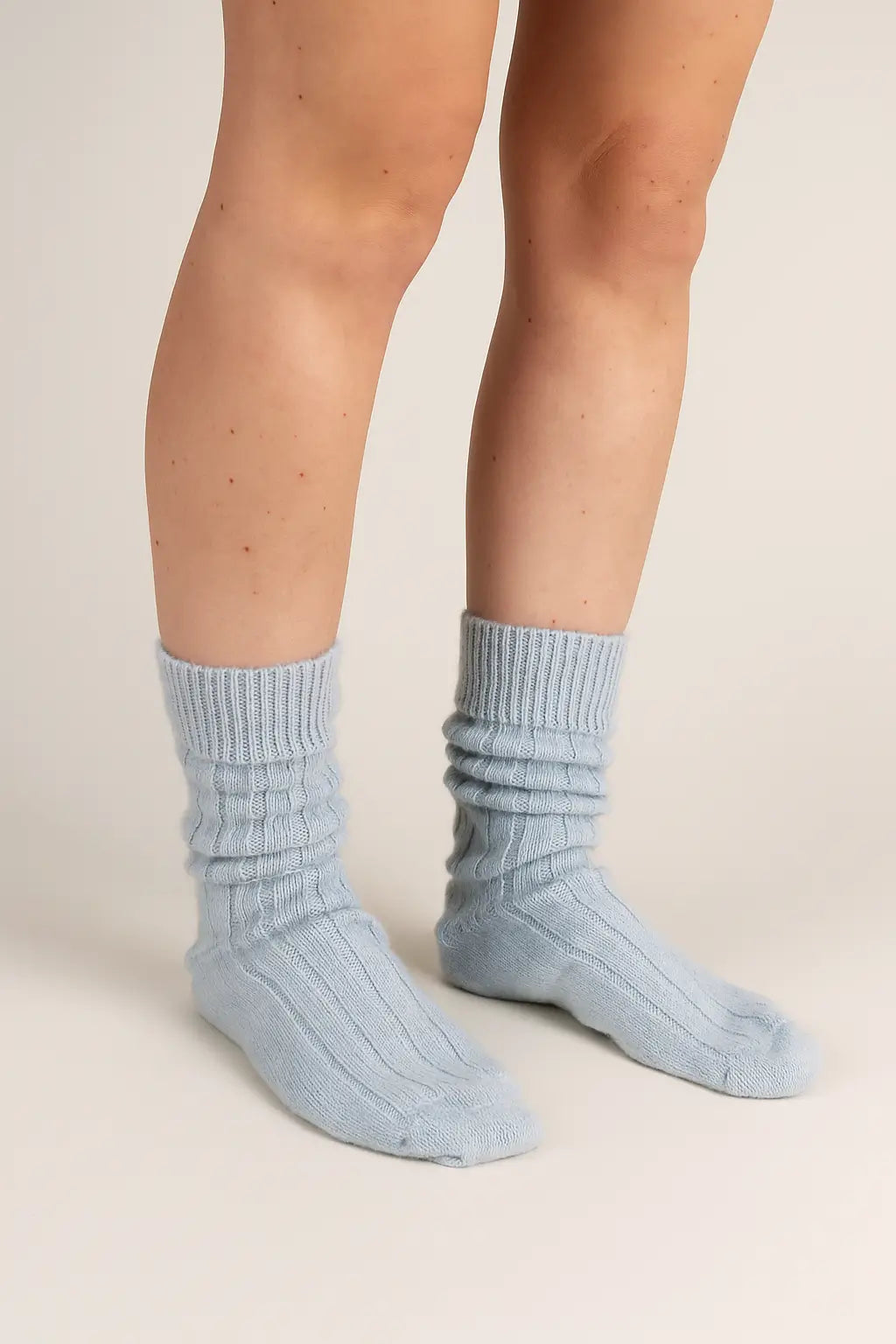 half british alpaca lounge socks in baby blue, worn and softly scrunched to show the ribbed knit and plush alpaca texture against a neutral background