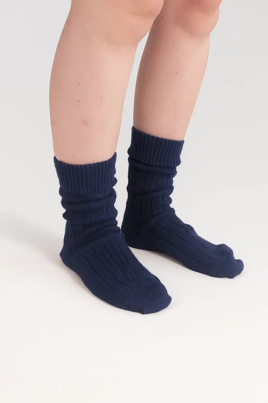 half british alpaca lounge socks in navy, worn slightly slouched to showcase the ribbed knit texture and soft alpaca wool against a background