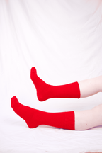 Red socks worn by a person on a white background