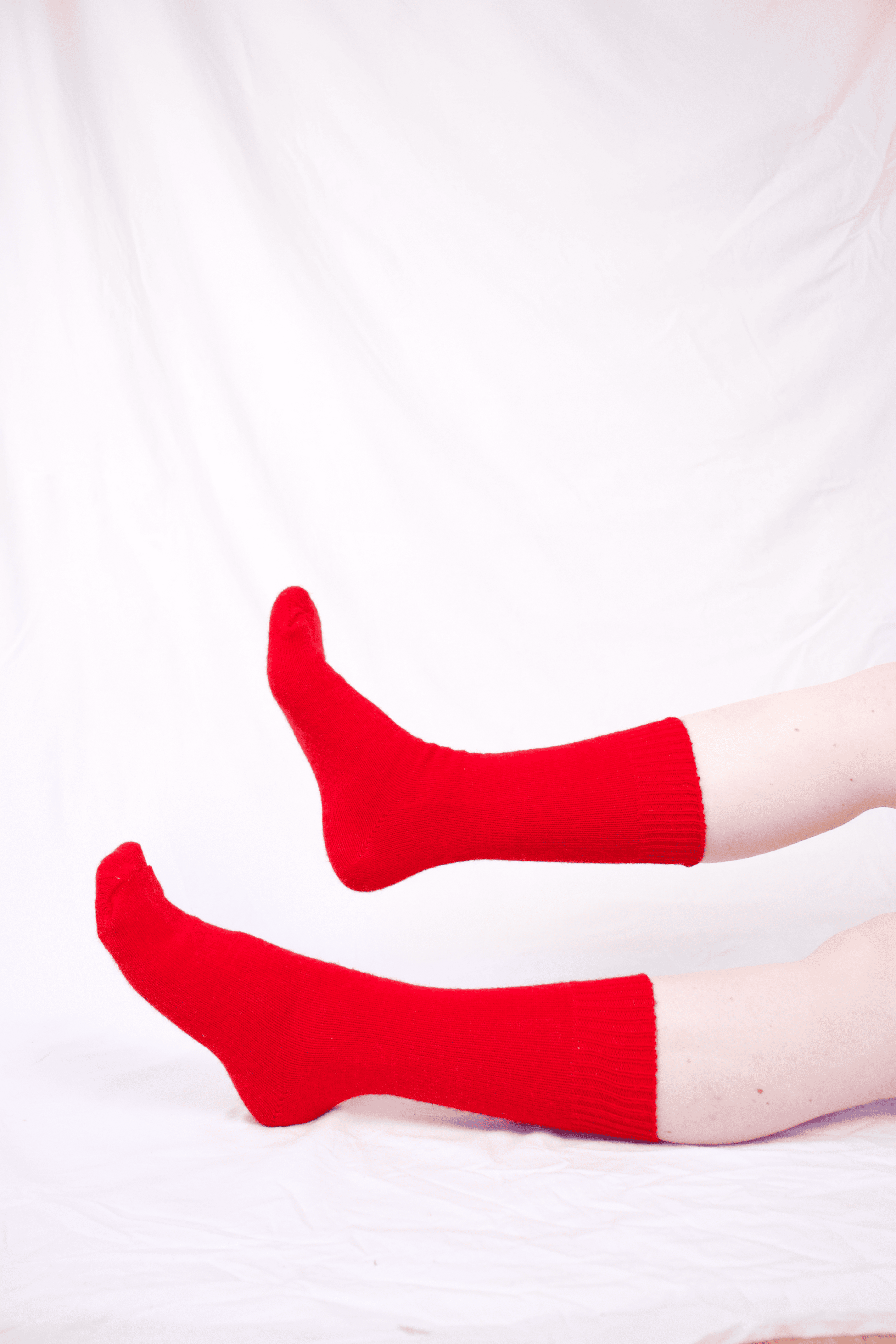 Red socks worn by a person on a white background