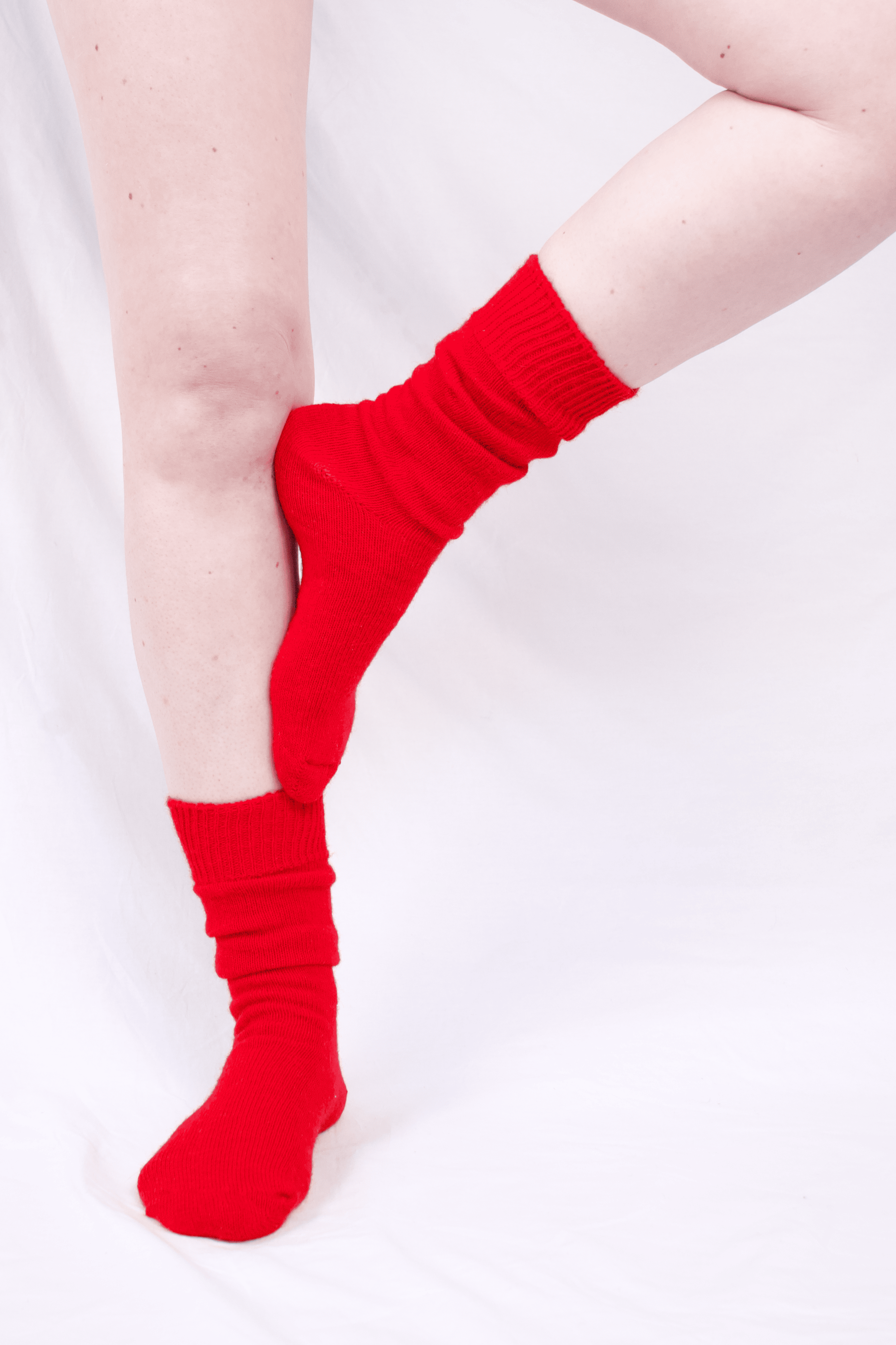 half british everyday alpaca socks in red, worn standing to show the soft alpaca wool texture and ribbed finish