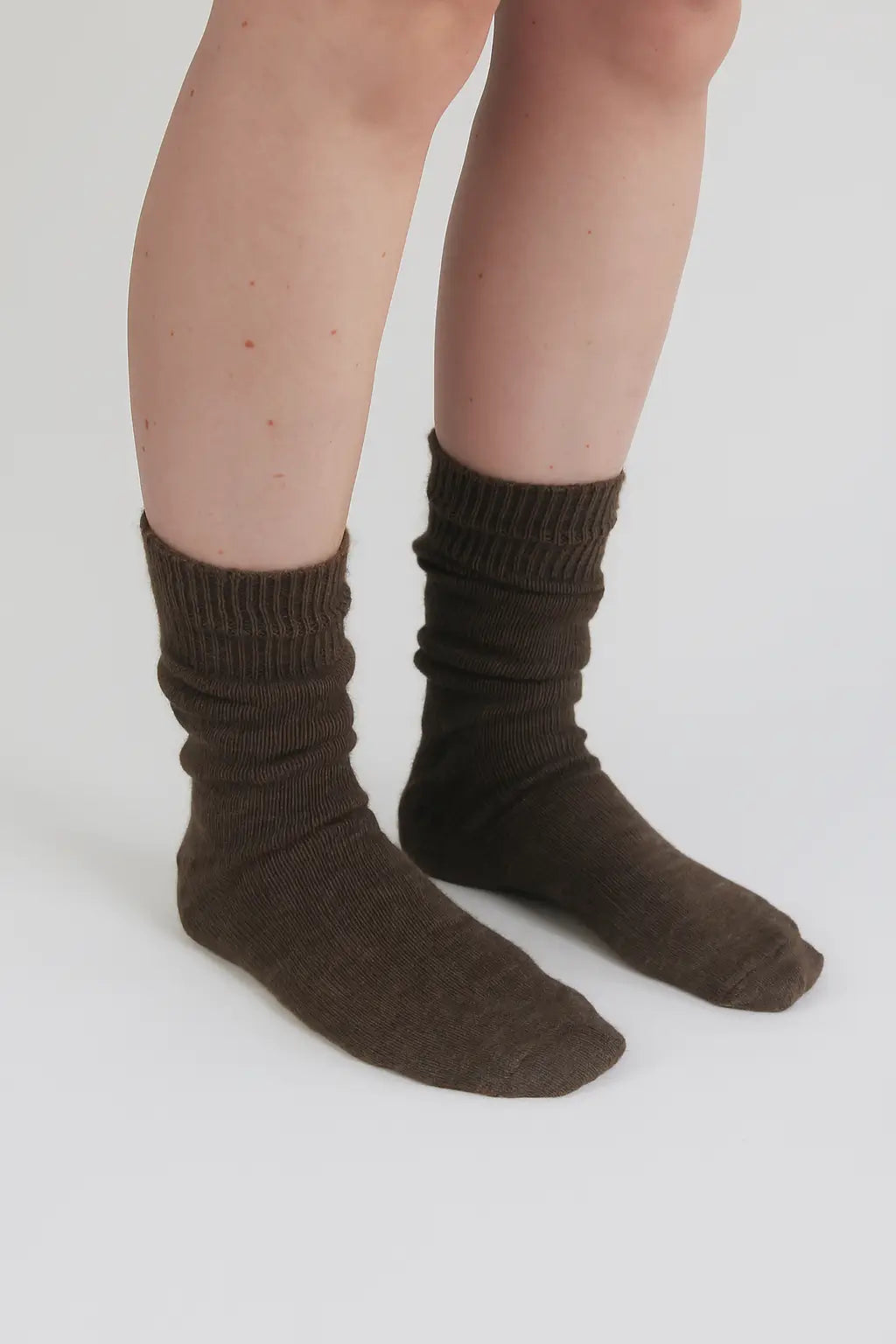 half british everyday alpaca socks in brown, worn and gently scrunched to show the ribbed knit texture and soft alpaca wool finish against a background