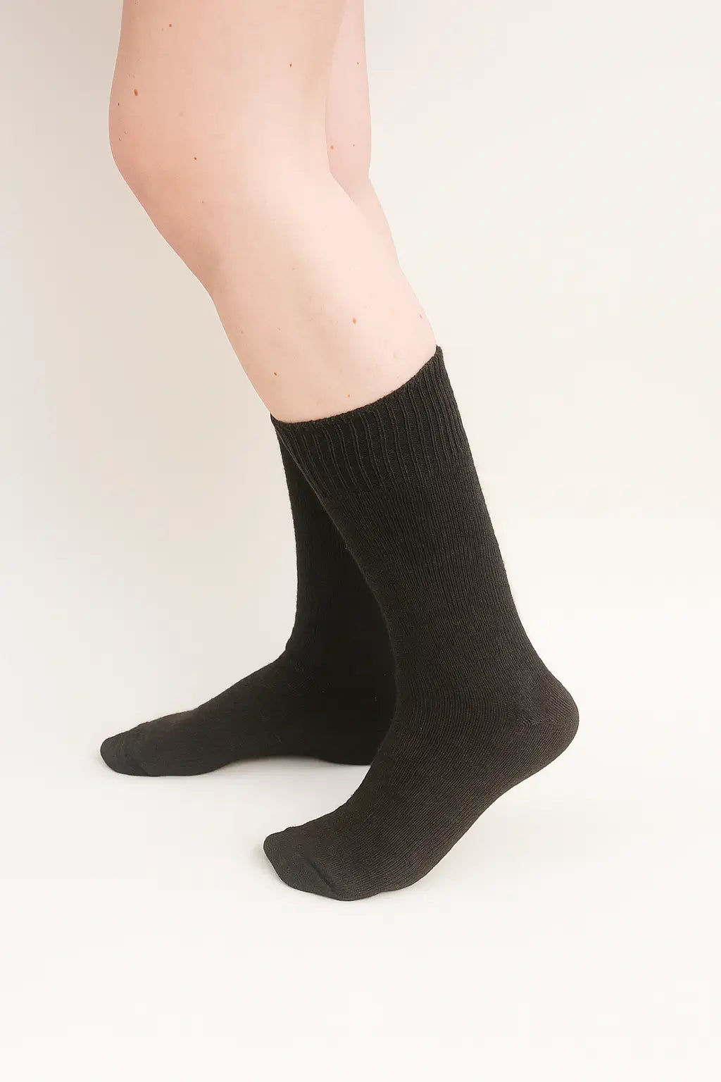 half british everyday alpaca socks in dark chocolate, worn to show the soft alpaca wool texture and fine ribbed design against a neutral background.