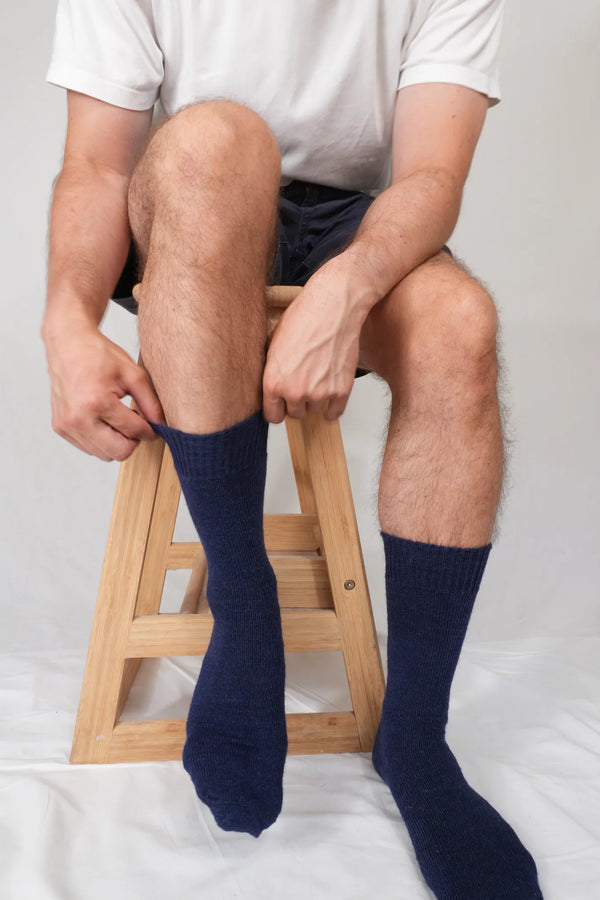 half british everyday alpaca socks in navy being put on, showing the fine ribbed knit and soft Peruvian alpaca wool